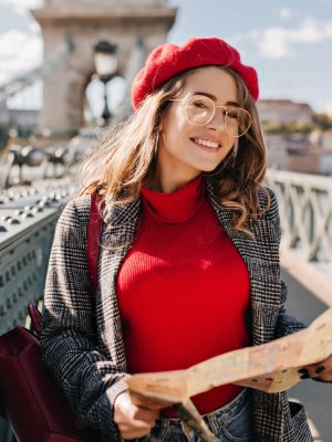 outdoor-photo-pretty-female-traveler-glasses-holding-map-city-bridge